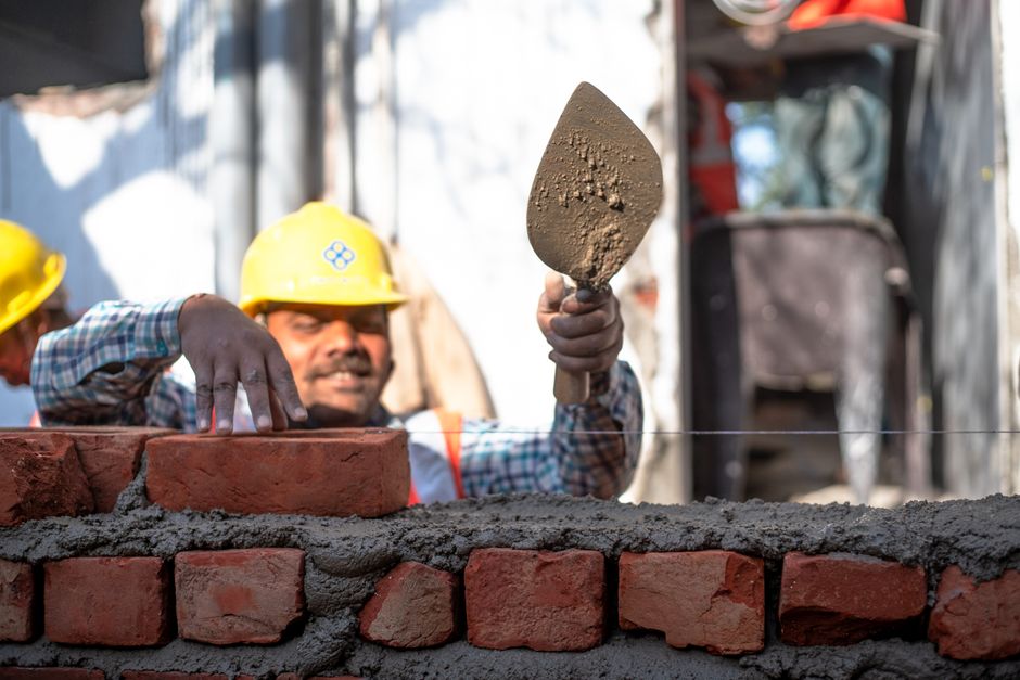 Master bricklayer performing precision masonry work